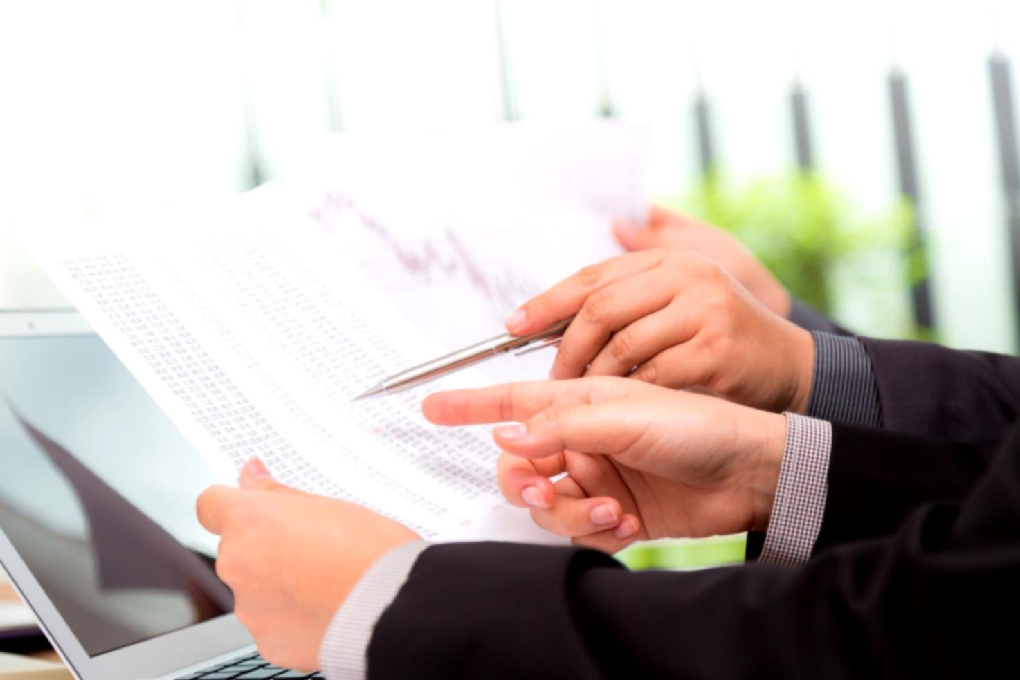 Professionnels analysant des graphiques financiers et des modèles d'affaires sur des écrans et documents